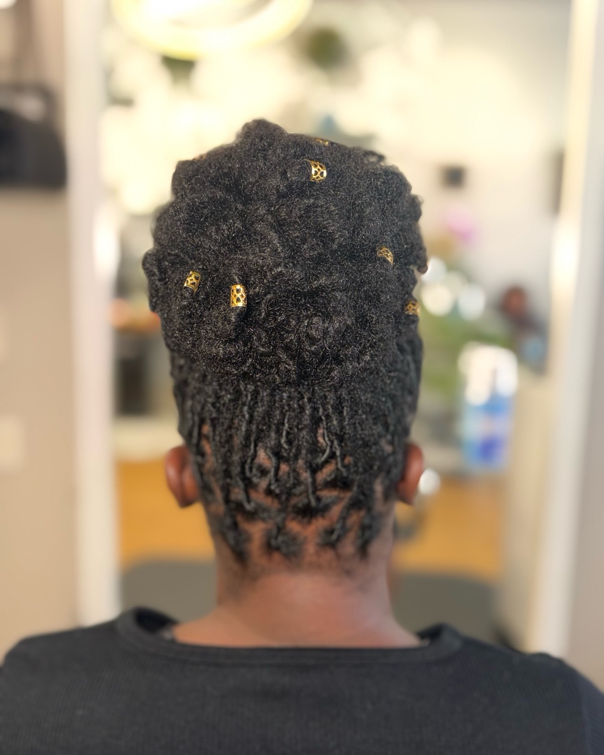 Loc updo with gold cuffs, back view styled at Royal Touch Studio